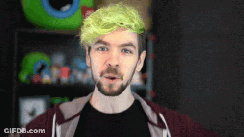 A Man With Green Hair And A Beard Is Wearing A Black Shirt GIF