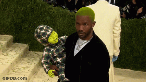 A Man With Green Hair Is Holding A Child With Shrek On It GIF
