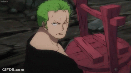 A Man With Green Hair Is Standing Next To A Red Chair That Says Bokuma.tv GIF