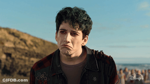A Man With Green Hair Is Wearing A Plaid Shirt And A Disney + Jacket GIF