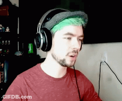 A Man With Green Hair Is Wearing Headphones And A Hat GIF