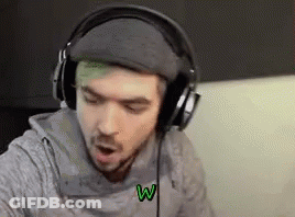A Man With Green Hair Is Wearing Headphones While Sitting On A Couch . GIF