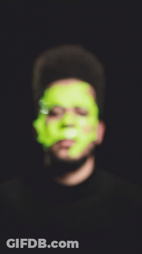 A Man With Green Tape On His Face Looking At The Camera GIF