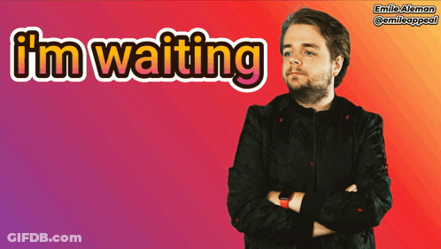 A Man With His Arms Crossed Is Standing In Front Of A Sign That Says I 'M Waiting GIF