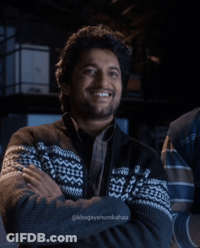 A Man With His Arms Crossed Is Wearing A Sweater With A Pattern On It GIF