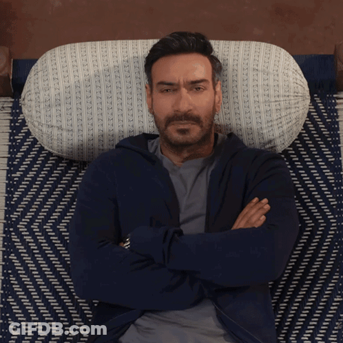 A Man With His Arms Crossed Laying On A Bed GIF