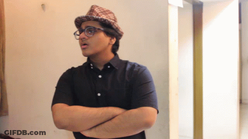 A Man With His Arms Crossed Wearing A Hat And Glasses GIF