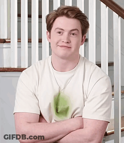 A Man With His Arms Crossed Wearing A Shirt That Says I Am Real GIF