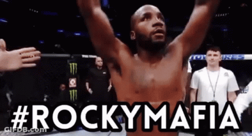 A Man With His Arms In The Air With #Rockymafia Written Above Him GIF