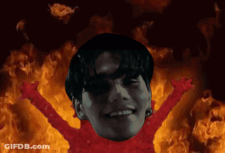 A Man With His Arms Outstretched In Front Of A Fire GIF