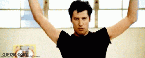 A Man With His Arms Outstretched In Front Of A Sign That Says Reserved On It GIF