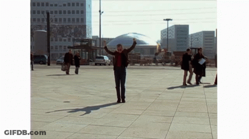 Man With Outstretched Arms In City Square GIF