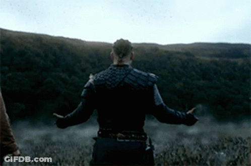 A Man With His Arms Outstretched Stands In A Field GIF