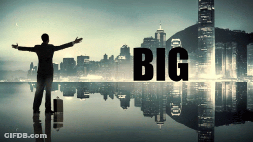 A Man With His Arms Outstretched Stands In Front Of A City With The Word Big On It GIF