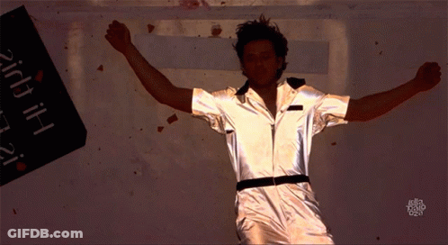 A Man With His Arms Outstretched Stands In Front Of A Sign That Says ' Hi ' GIF