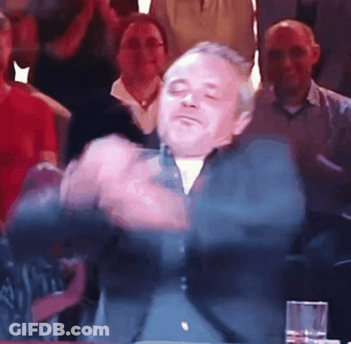 A Man With His Eyes Closed Is Dancing In Front Of A Crowd GIF