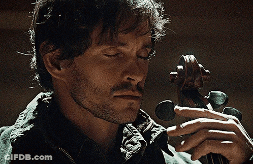 A Man With His Eyes Closed Is Holding A Violin In His Hands GIF