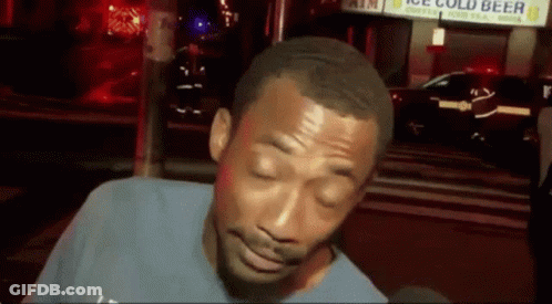 A Man With His Eyes Closed Is Standing In Front Of A Sign That Says Ice Cold Beer GIF