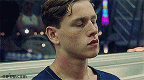 A Man With His Eyes Closed Is Wearing A Blue Shirt . GIF