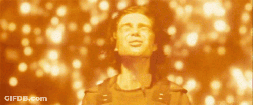 A Man With His Eyes Closed Stands In Front Of A Blurred Background Of Lights GIF