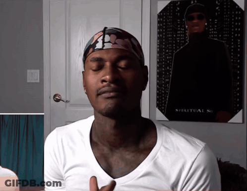 A Man With His Eyes Closed Stands In Front Of A Poster That Says Spiritual So GIF