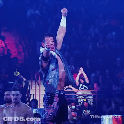 A Man With His Fist In The Air In Front Of A Crowd With Tiffany24 Written On The Bottom GIF