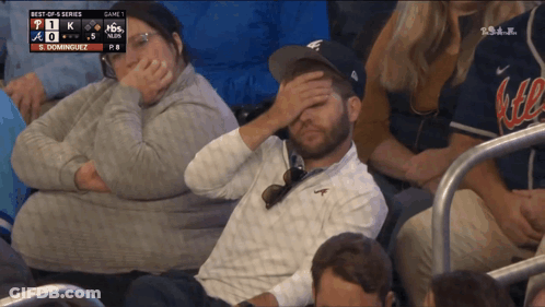 A Man With His Hand On His Forehead Is Watching A Baseball Game Between The Braves And The Dodgers GIF