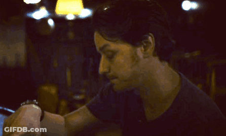 A Man With His Hand On His Forehead Looks Down GIF
