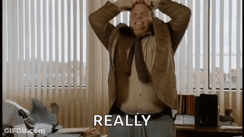 A Man With His Hands On His Head Is Standing In Front Of A Window With The Word Really Written On It . GIF