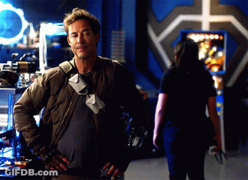 A Man With His Hands On His Hips Stands In Front Of A Woman GIF
