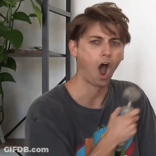A Man With His Mouth Open Is Holding A Hammer In His Hand GIF