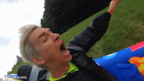 A Man With His Mouth Open Is Laying On A Colorful Raft GIF