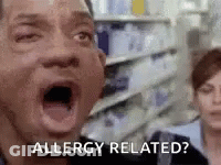 A Man With His Mouth Open Is Saying `` Allergy Related ? '' In A Grocery Store . GIF