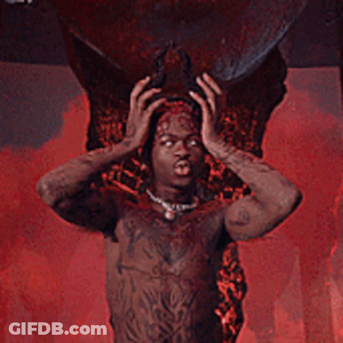 A Man With Horns And Wings Is Standing In Front Of A Large Skull GIF