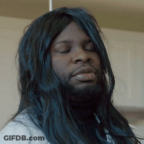 A Man With Long Black Hair And A Beard Looks Down With His Eyes Closed GIF