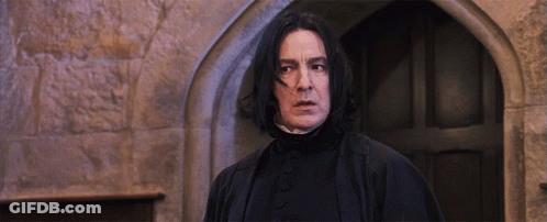 A Man With Long Black Hair Is Standing In Front Of A Doorway GIF