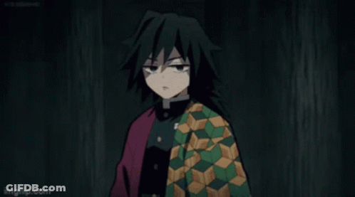 A Man With Long Black Hair Is Wearing A Green And Red Jacket And Making A Face . GIF
