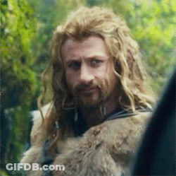 A Man With Long Blonde Hair And A Beard Is Looking At Something . GIF