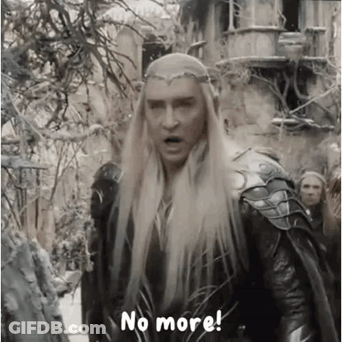 A Man With Long Blonde Hair And A Crown On His Head Is Standing In Front Of A Group Of People . GIF