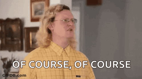 A Man With Long Blonde Hair And Glasses Is Standing In A Living Room . GIF