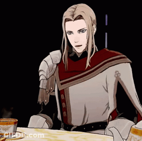A Man With Long Blonde Hair Is Sitting At A Table With A Cup Of Tea GIF