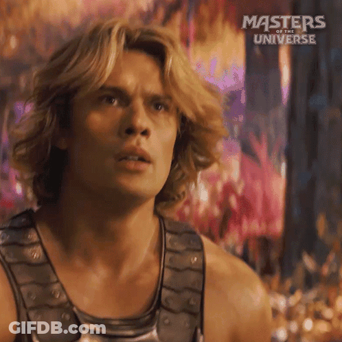 A Man With Long Blonde Hair Is Wearing A Tank Top From The Movie Masters Of The Universe GIF