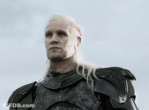 A Man With Long Blonde Hair Is Wearing Armor And Looking Up At The Sky GIF