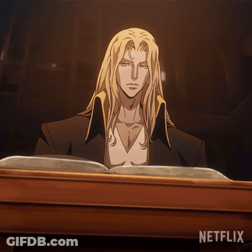 A Man With Long Blonde Hair Sits At A Table Reading A Book With Netflix Written On The Bottom GIF