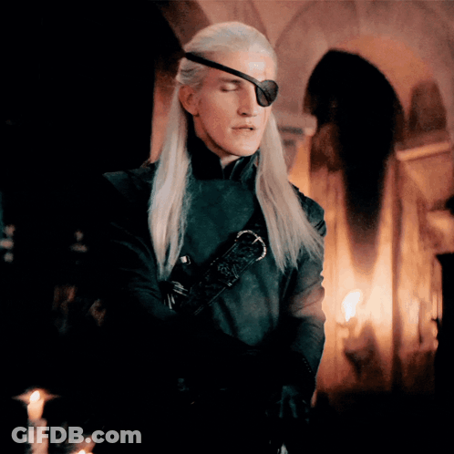 A Man With Long Blonde Hair Wearing A Black Eye Patch GIF