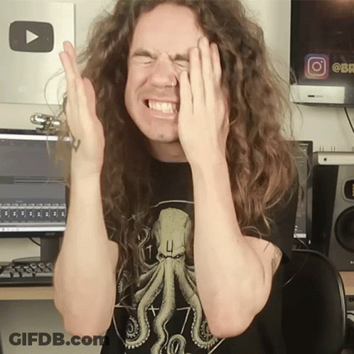 A Man With Long Curly Hair Covering His Face With His Hands GIF