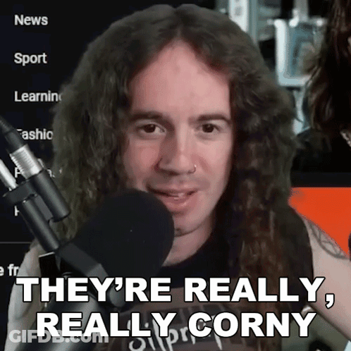 A Man With Long Curly Hair Is Holding A Microphone And Says They 'Re Really Really Corny GIF