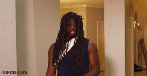 A Man With Long Dreadlocks And A White Scarf Around His Neck GIF