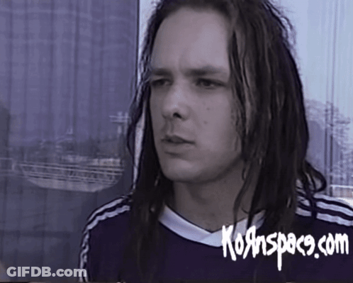 A Man With Long Dreadlocks Is Wearing A Shirt That Says Kornspace.com On It GIF