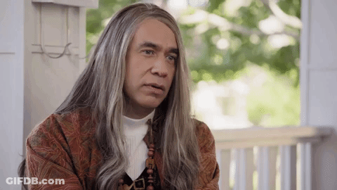 A Man With Long Gray Hair Is Sitting On A Porch . GIF